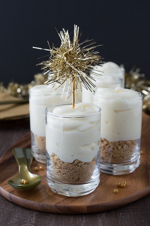 Make these fancy and easy white chocolate champagne cheesecake shooters for New Years Eve! I LOVE the gold tinsel toppers!