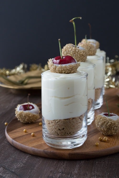 Make these fancy and easy white chocolate champagne cheesecake shooters for New Years Eve! I LOVE the cherries dipped in gold sprinkles! 