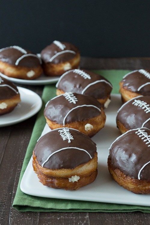 Cream Filled Chocolate Football Donuts - use refrigerated biscuits to make cream filled donuts! Decorate them to look like footballs for game day! 