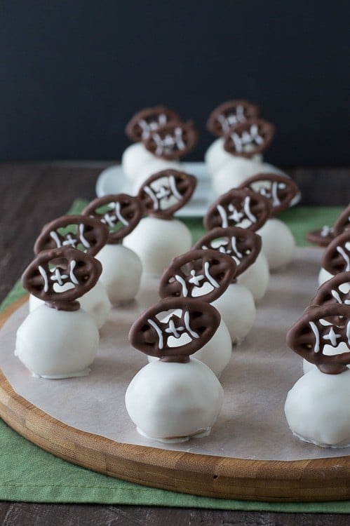 Football Oreo Balls - golden oreo balls dipped in white chocolate and topped with football pretzels! Make these for game day!