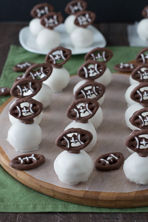 Football Oreo Balls - golden oreo balls dipped in white chocolate and topped with football pretzels! Make these for game day!