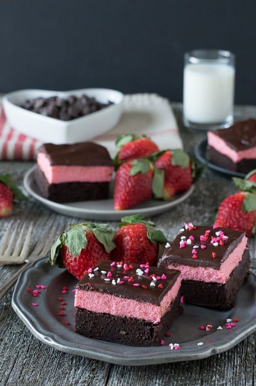 Layered Strawberry Mousse Brownies - a rich chocolate brownie topped with strawberry mousse and chocolate ganache. A favorite for Valentine’s Day!