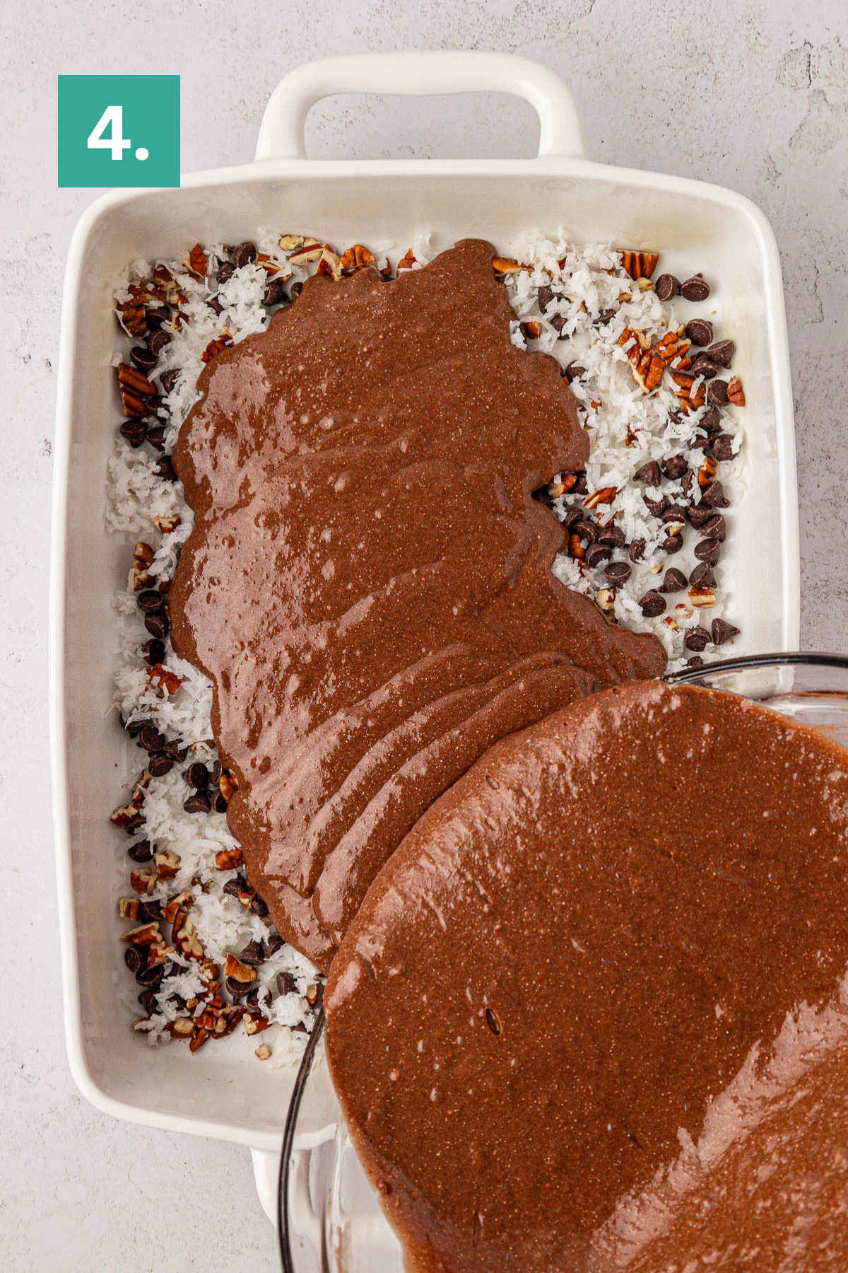 A glass bowl pours chocolate batter for an earthquake cake over shredded coconut, chocolate chips, and chopped pecans in a white baking dish. A green box with the number 4 appears in the top left corner.