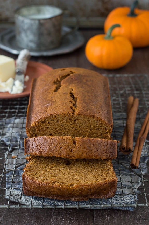 pumpkin bread loaf sliced into 2 pieces on metal cooling rack