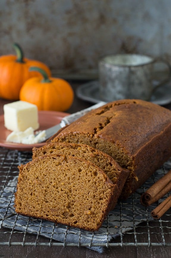 pumpkin bread loaf sliced into 2 pieces on metal cooling rack