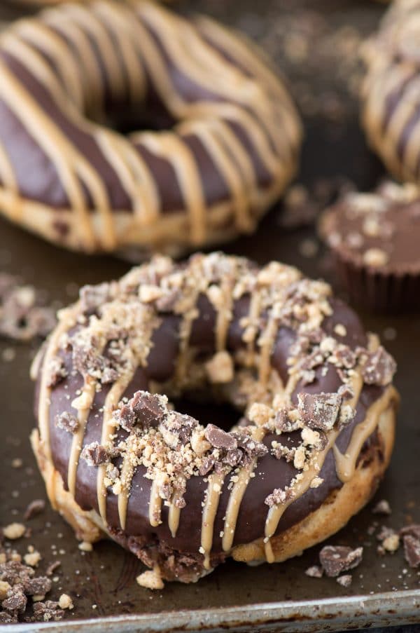 Love peanut butter cups? Make homemade donuts stuffed with peanut butter cups, topped with chocolate ganache and peanut butter drizzle. Stuffed Peanut Butter Cup Donuts! 