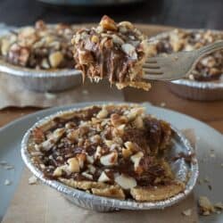 No bake mini pies with 2 layers of mixed nuts and a rich chocolate filling - top them with chocolate and caramel!