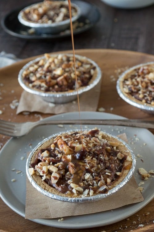 No bake mini pies with 2 layers of mixed nuts and a rich chocolate filling, all topped with chocolate and caramel!