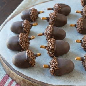 Adorable and delicious oreo acorn ball desserts on a round wooden board.