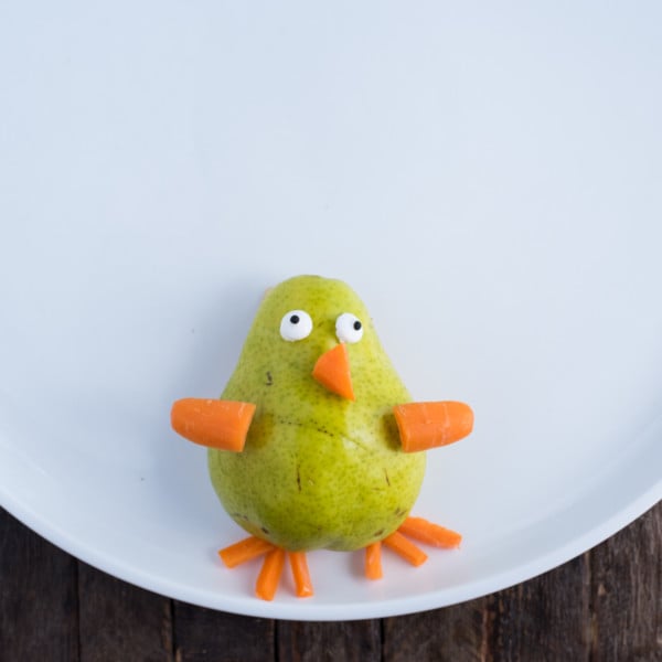 turkey fruit platter with pear for the turkey’s body and carrots for the beak, wings, and legs
