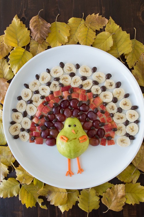 fruit platter in the shape of a turkey on a white serving tray