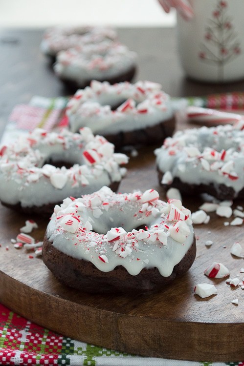 Baked chocolate donuts infused with peppermint flavor, topped with white chocolate and crushed candy canes. 