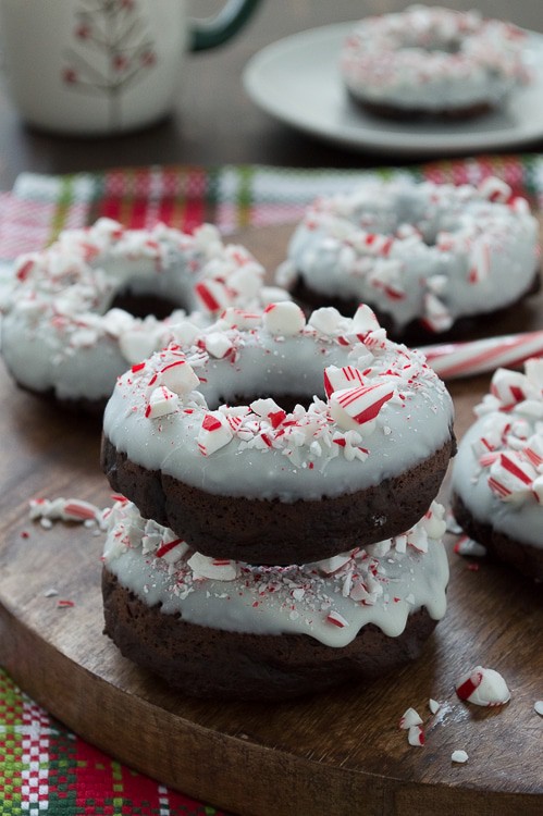 Baked chocolate donuts infused with peppermint flavor, topped with white chocolate and crushed candy canes. 