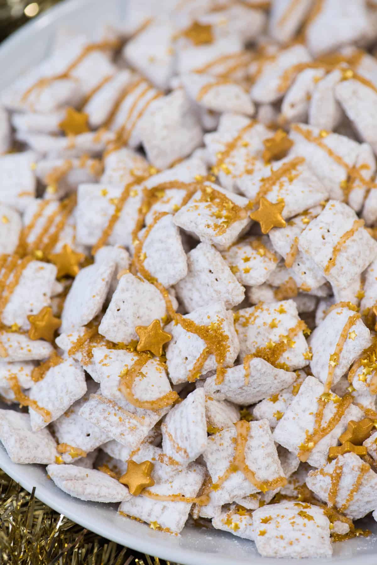 new year’s eve white chocolate puppy chow with gold sprinkles and gold stars inside a white bowl