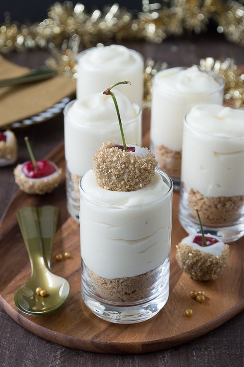 Make these fancy and easy white chocolate champagne cheesecake shooters for New Years Eve! I LOVE the cherries dipped in gold sprinkles! 