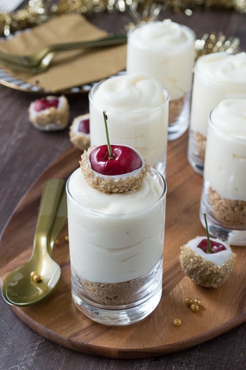 Make these fancy and easy white chocolate champagne cheesecake shooters for New Years Eve! I LOVE the cherries dipped in gold sprinkles! 