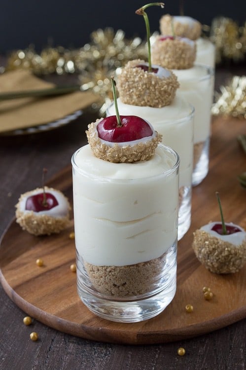 Make these fancy and easy white chocolate champagne cheesecake shooters for New Years Eve! I LOVE the cherries dipped in gold sprinkles! 