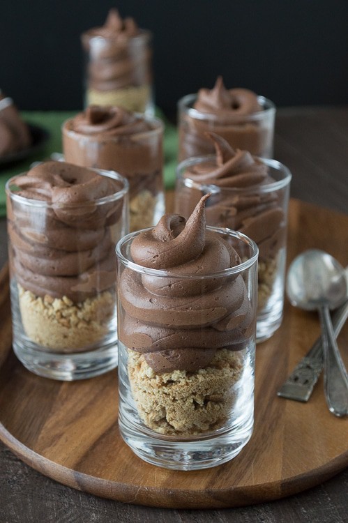 Chocolate cheesecake football dessert shooters topped with peanut butter stuffed chocolate footballs. A great recipe for game day!