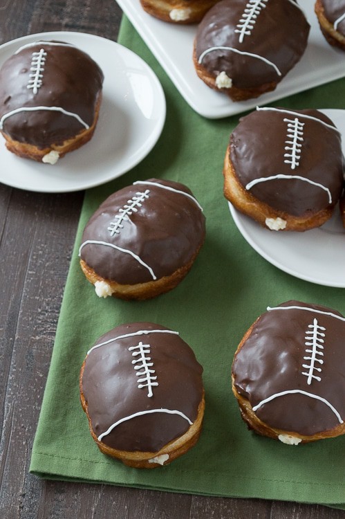 Cream Filled Chocolate Football Donuts - use refrigerated biscuits to make cream filled donuts! Decorate them to look like footballs for game day! 