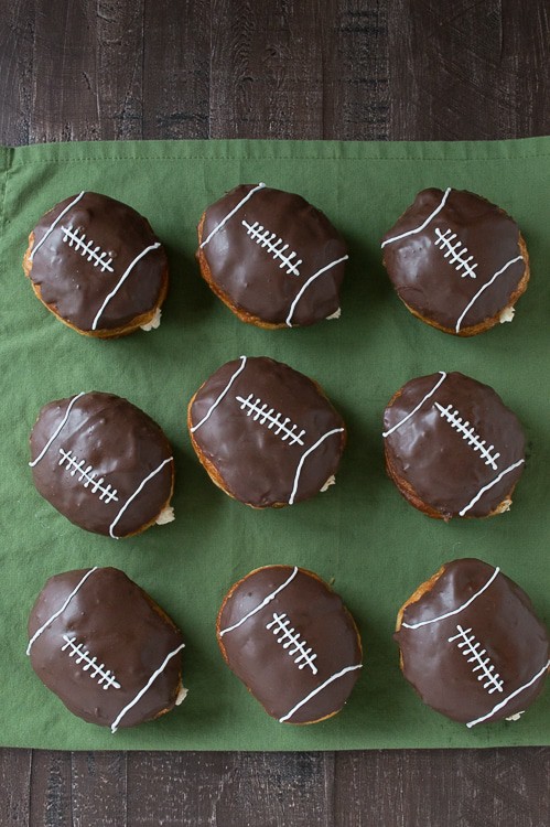 Cream Filled Chocolate Football Donuts - use refrigerated biscuits to make cream filled donuts! Decorate them to look like footballs for game day! 