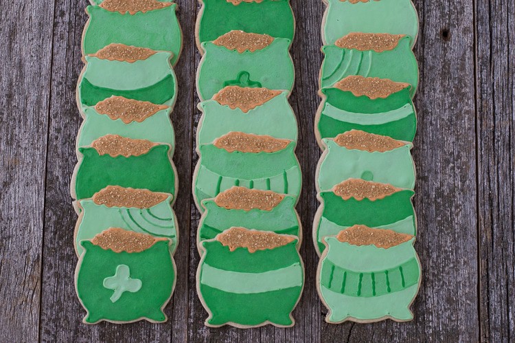 Eighteen homemade Pot o' Gold Cookies on a wooden table.