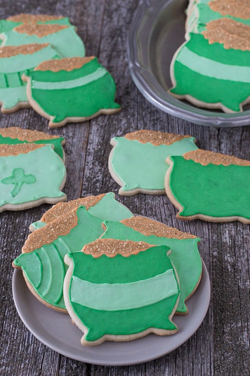Four homemade Pot o' Gold Cookies on a small serving plate on a wooden table. 