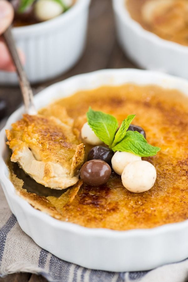 Your guide to making easy espresso creme brûlée at home! Coffee creme brûlée is a decedent dessert that’s actually easy to make with 5 ingredients. Plus learn about what ramekins to use and how to make creme brûlée without a torch. espresso creme brûlée in white round ramekin with chocolate covered coffee beans and mint leaf on top of creme brûlée
