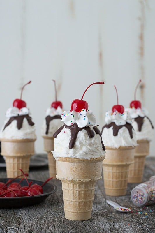 Ice Cream Cone Cupcakes with Cherries and Sprinkles on the side.