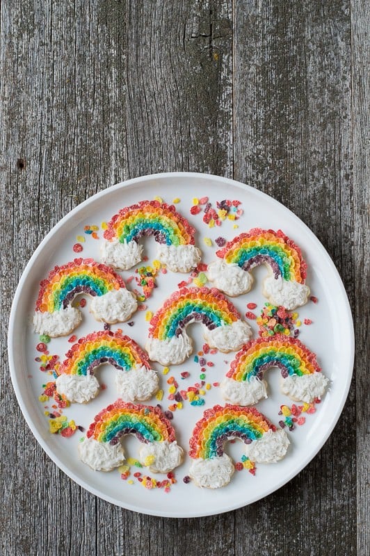 Assortment of Eight delicious Rainbow Sugar Cookies on a large white serving plate on a wooden table. 