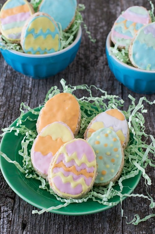 Five Rice Krispies Easter Eggs on fake green grass on a green plate on a wooden table.