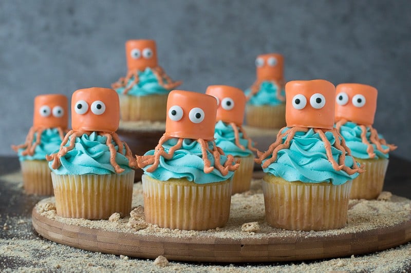 Eight delicious Octopus Cupcakes arranged on on a wooden board for the perfect under the sea party!