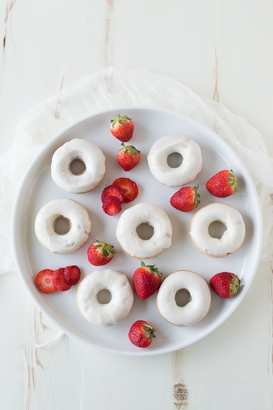 Strawberry Cheesecake Donuts with strawberries in the batter, topped with a cream cheese glaze and strawberry coulis. 