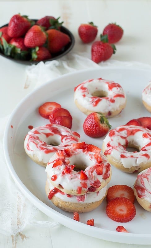 Strawberry Cheesecake Donuts with strawberries in the batter, topped with a cream cheese glaze and strawberry coulis. 