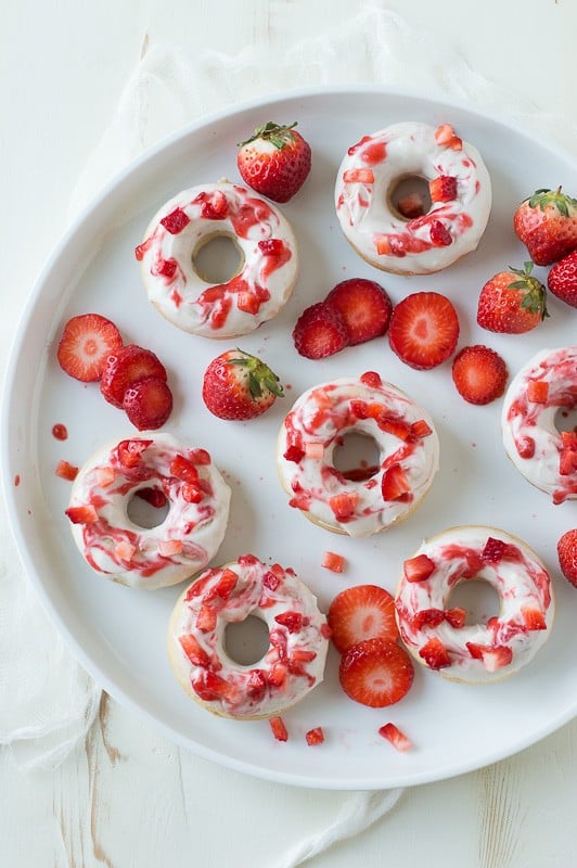 Strawberry Cheesecake Donuts with strawberries in the batter, topped with a cream cheese glaze and strawberry coulis. 