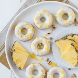 Pineapple Walnut Donuts with a white chocolate glaze and pineapple puree drizzle!