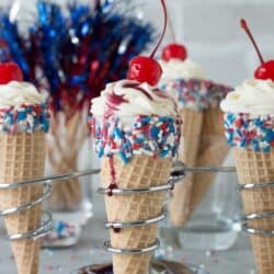 4th of July Cheesecake Ice Cream Cones - no bake vanilla cheesecake piped into 4th of july ice cream cones!