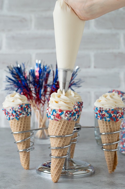 4th of July Cheesecake Ice Cream Cones - no bake vanilla cheesecake piped into 4th of july ice cream cones! 