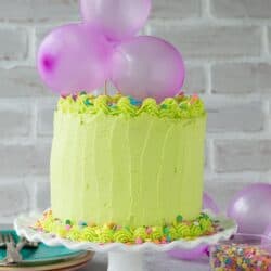 Homemade funfetti cake with lime green buttercream! Top the cake with a DIY balloon cake topper!
