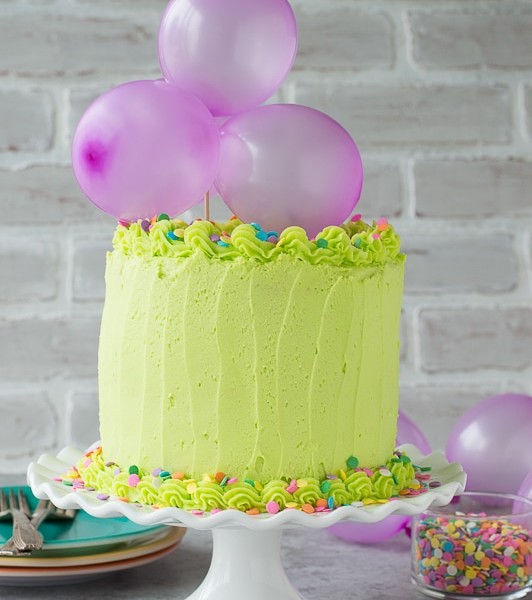 Homemade funfetti cake with lime green buttercream! Top the cake with a DIY balloon cake topper!