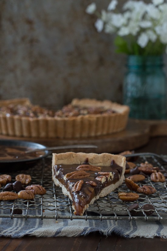 This turtle tart is swirled with caramel and chocolate then topped with pecans and sea salt! 