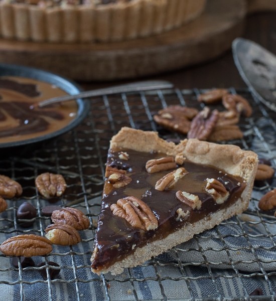 This turtle tart is swirled with caramel and chocolate then topped with pecans and sea salt!