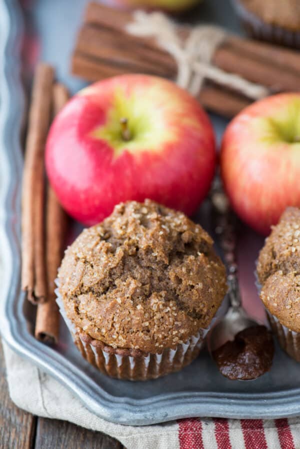 apple butter muffins on metal serving tray with apples and tan and red striped towel