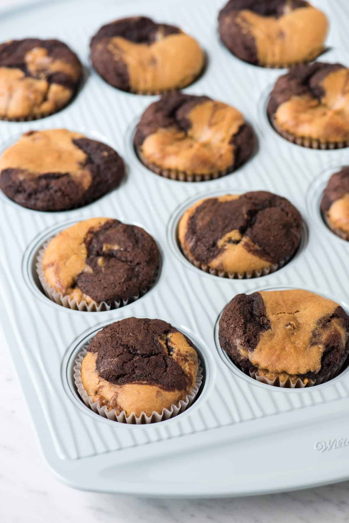 unfrosted chocolate peanut butter cupcakes in blue muffin pan