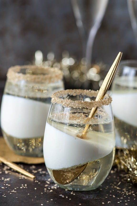 champagne jello cup shots with gold sprinkles on the glass rim on dark background