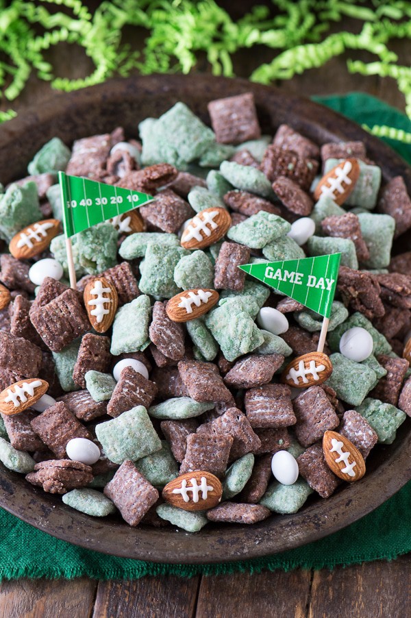 green and brown Football Puppy Chow with almonds that look like footballs and Game Day Flags in metal plate