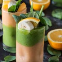Two layer green monster orange smoothie - healthy and easy to make! Top the smoothie with a fruit skewer.