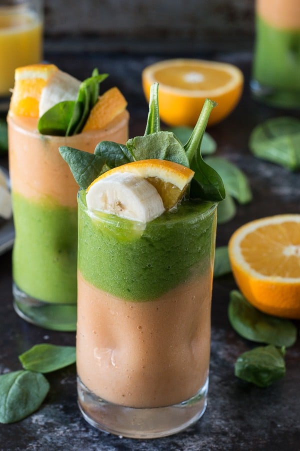 Two layer green monster orange smoothie - healthy and easy to make! Top the smoothie with a fruit skewer. 