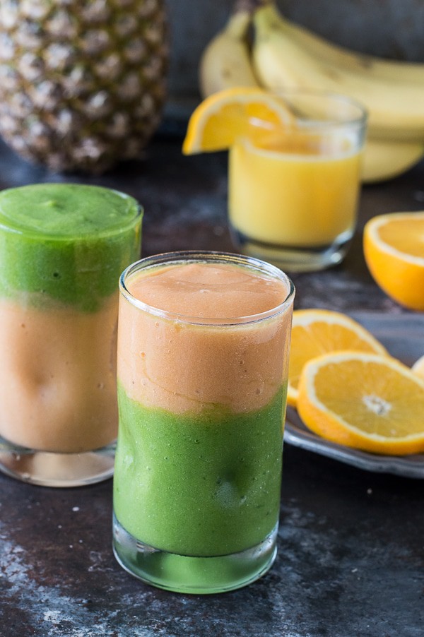Two layer green monster orange smoothie - healthy and easy to make! Top the smoothie with a fruit skewer. 