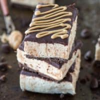 No bake buckeye bar recipe with a chocolate crust, creamy peanut butter filling, and topped with chocolate ganache. Serve them chilled or frozen!