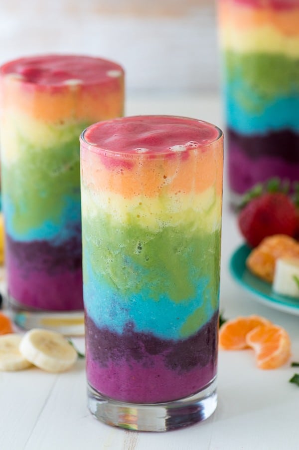 Beautiful 7 layer rainbow smoothie recipe! Full of tons of fruit and topped with a fruit skewer, it’s the ultimate rainbow smoothie! 